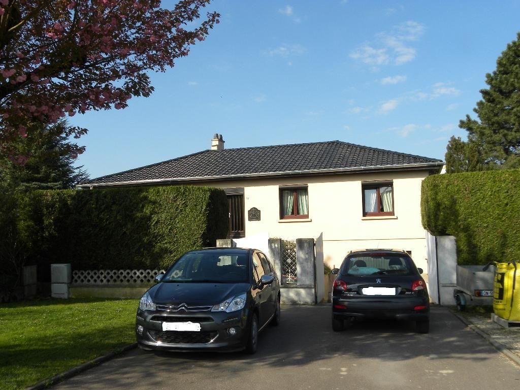 Maison au toit de tuiles sombres sous un ciel bleu