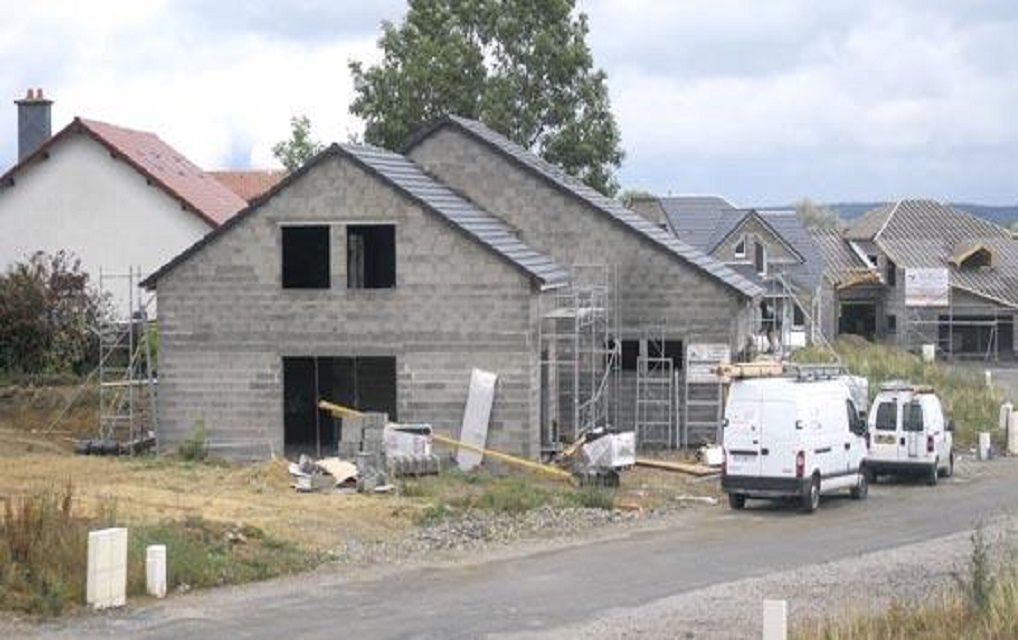 Maisons neuves en cours de couverture et camionnettes